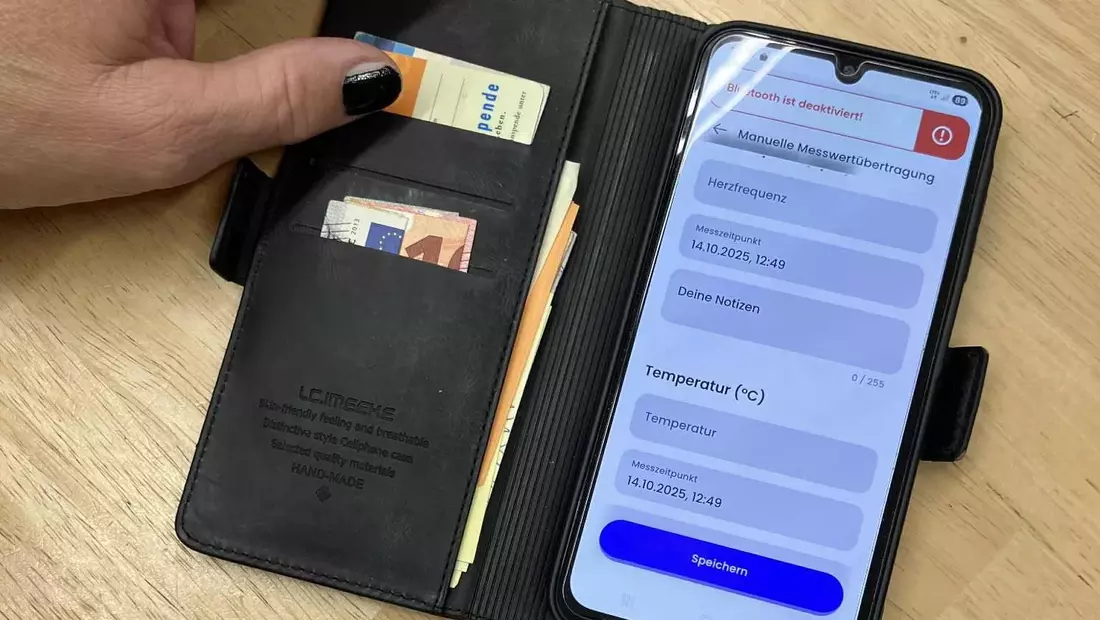 Ein angeschaltetes Handy liegt auf einem Tisch und zeigt die Nutzungsoberflächer der Herz-App.