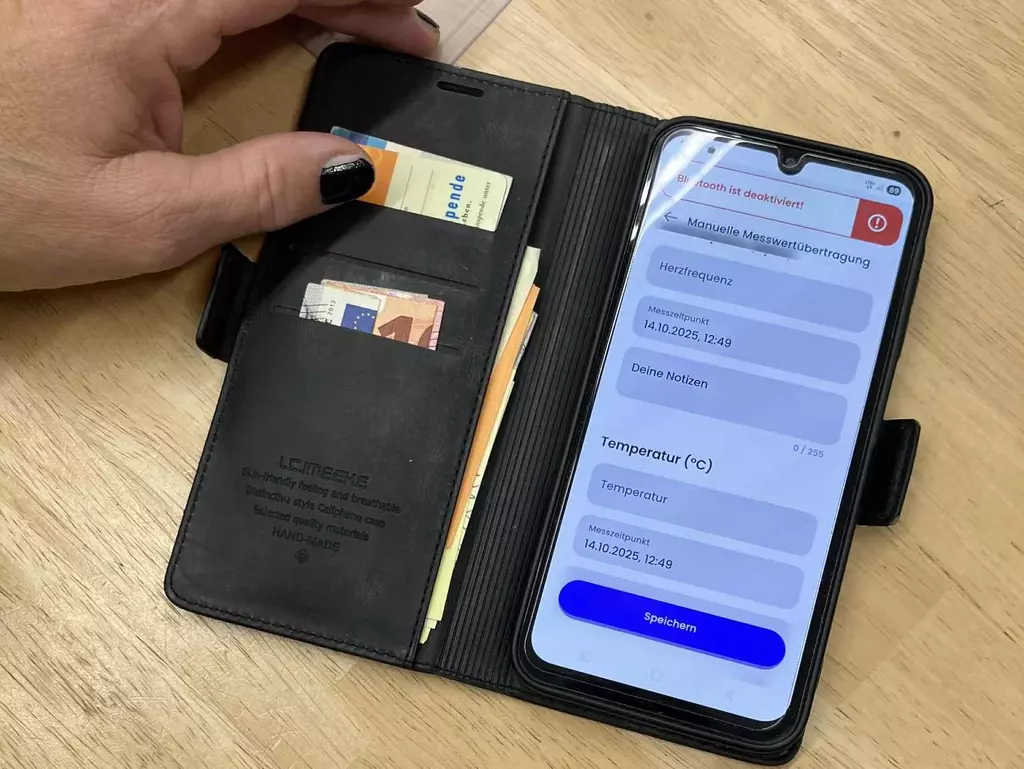 Ein angeschaltetes Handy liegt auf einem Tisch und zeigt die Nutzungsoberflächer der Herz-App.