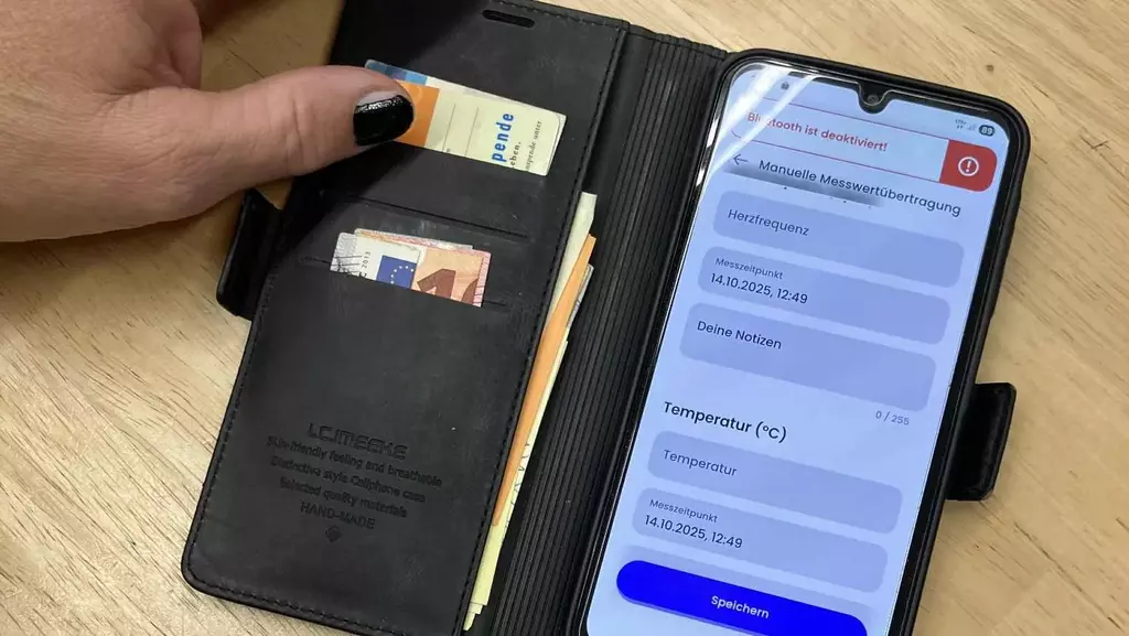Ein angeschaltetes Handy liegt auf einem Tisch und zeigt die Nutzungsoberflächer der Herz-App.
