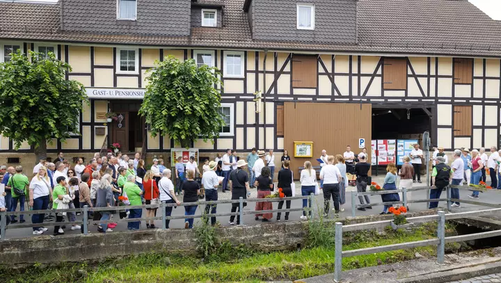 Menschen vor einem alten Gasthaus in Roßbach