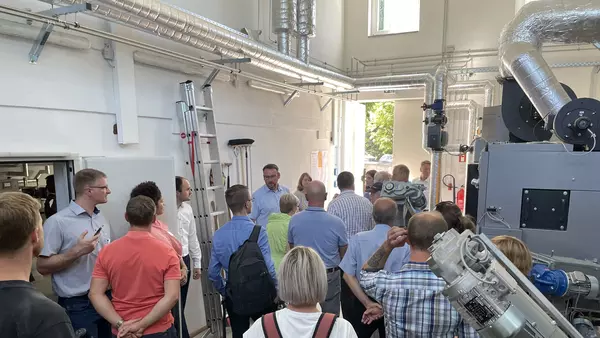 Eine Gruppe von Menschen im Heizhaus des Nahwärmenetzes in Kaltennordheim