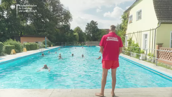 Ein Rettungsschwimmer steht am Beckenrand im Freibad Fredersdorf