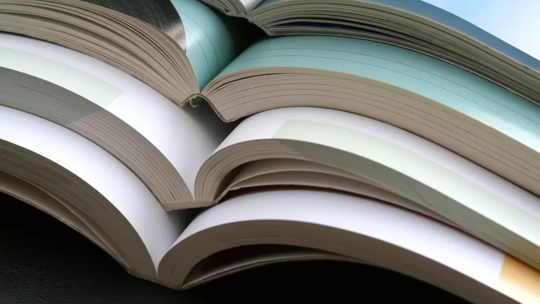Ein Stapel aufgeklappter Bücher