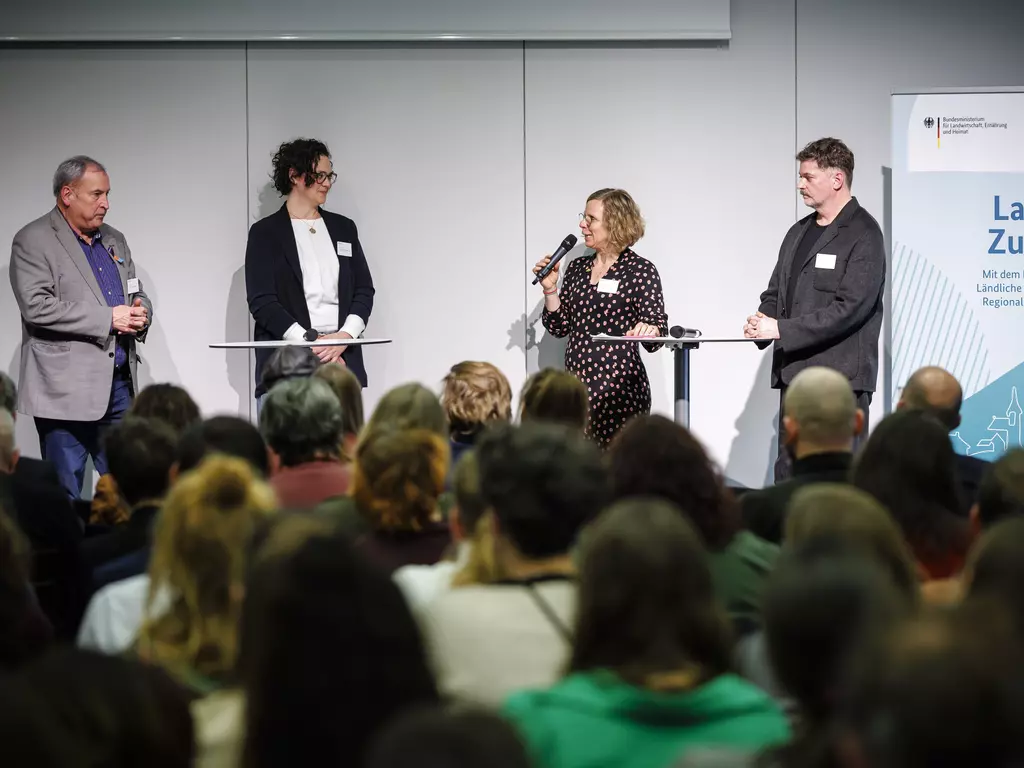 Teilnehmende diskutieren auf der Bühne