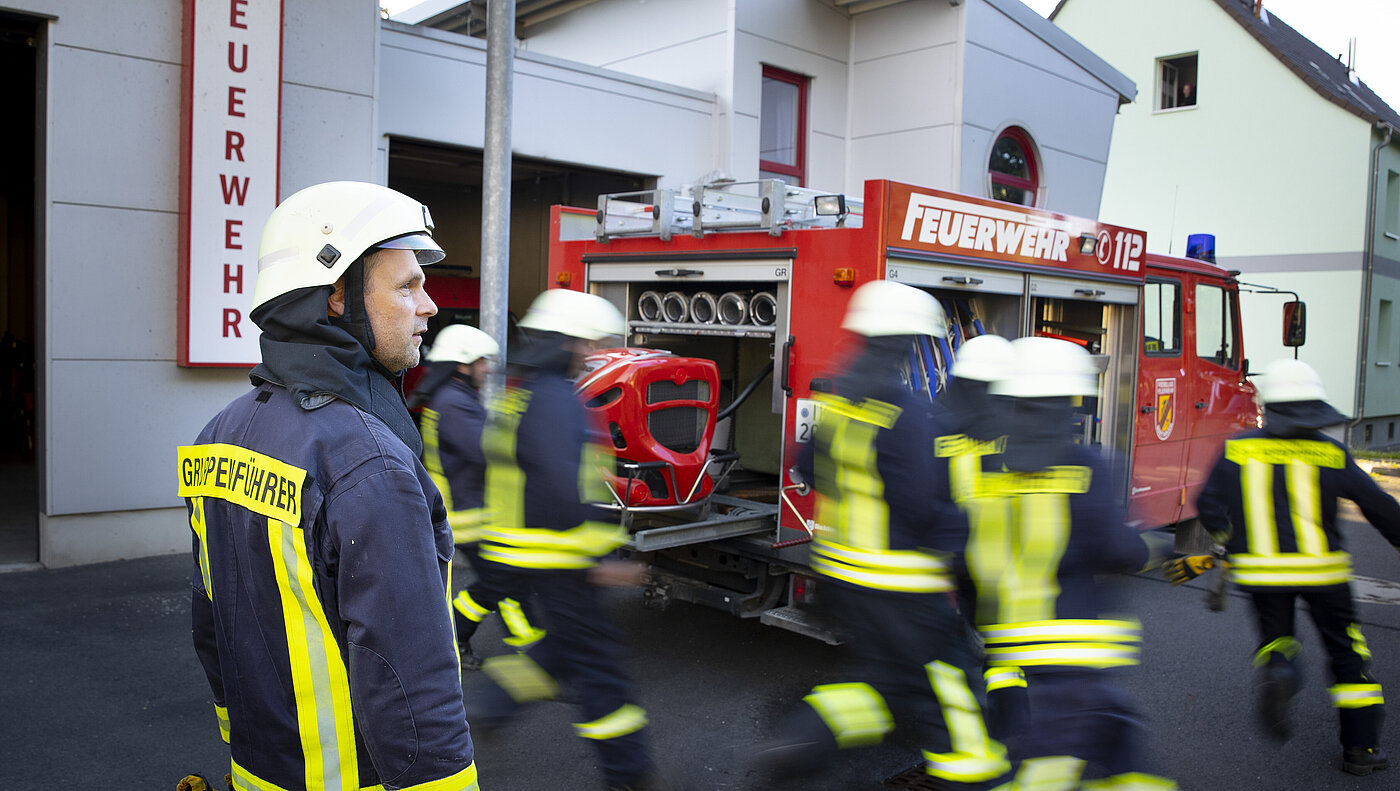 Feuerwehrleute in Uniform vor einem Einsatzwagen