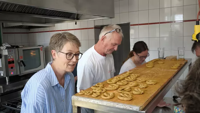 Workshopteilnehmende lernen vom Bäcker, wie Störkringel gebacken werden