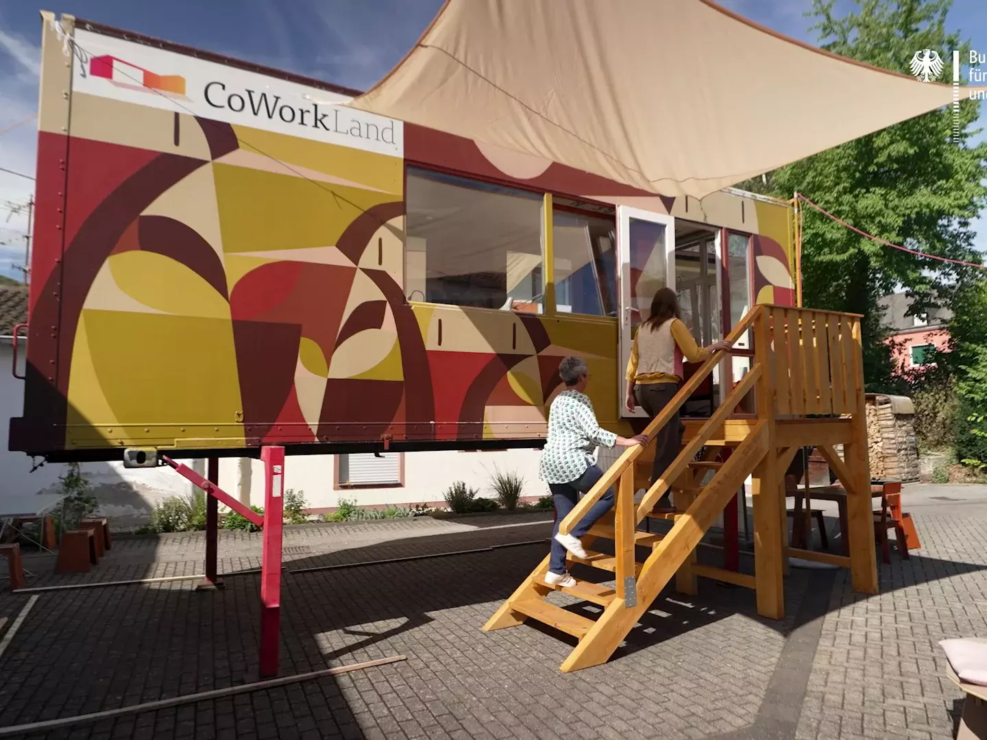 Zwei Frauen betreten einen Coworking-Container