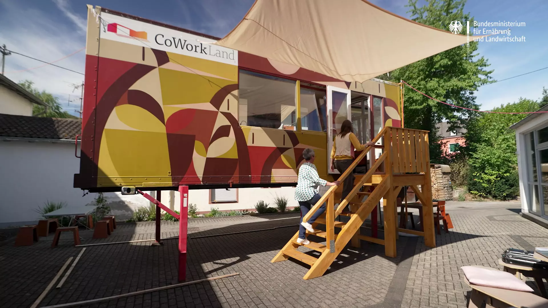 Zwei Frauen betreten einen Coworking-Container