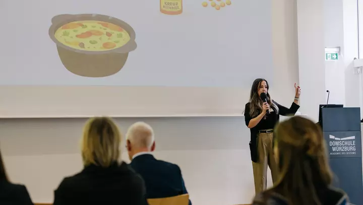 Eine Frau hält eine Präsentation auf einer Bühne ab.