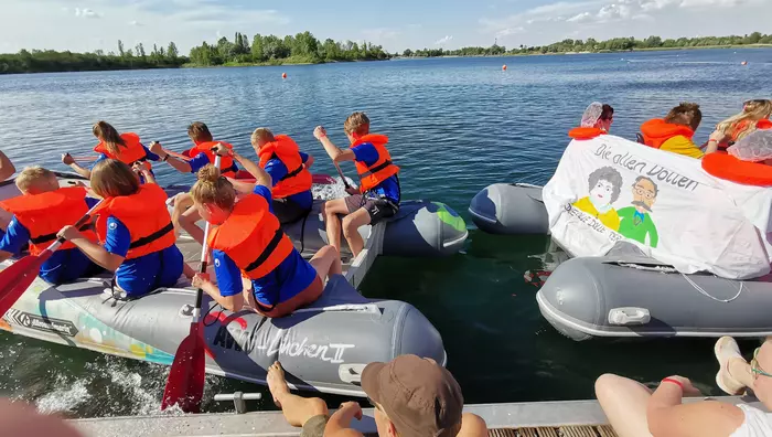 Kinder mit Rettungswesten bei einer Bootsrallye auf einem See