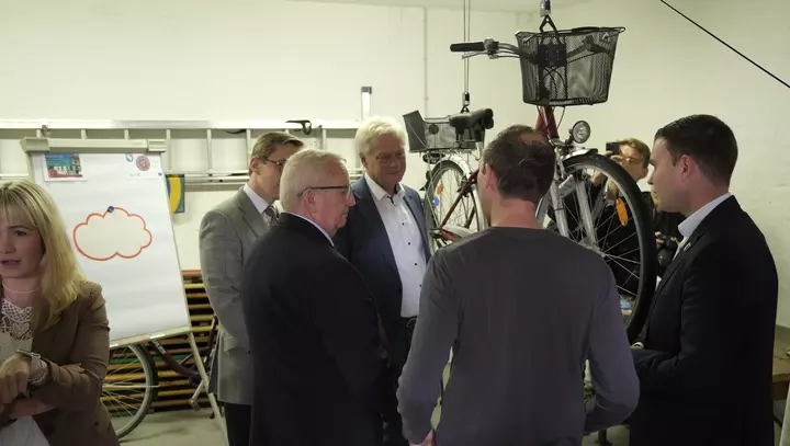Bundesminister Alois Rainer und vier weitere Personen in der Fahrradwerkstatt der "Flotten Bürger von Röbel"