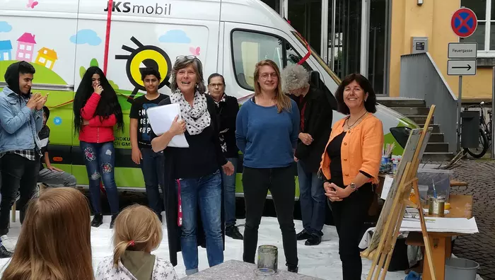 Jugendliche und Kunstpädagoginnen vor dem JKS Mobil