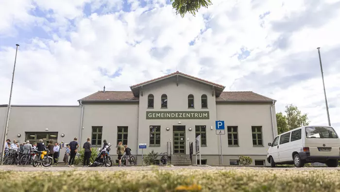 Menschen mit Fahrrädern stehen vor dem Gemeindezentrum.