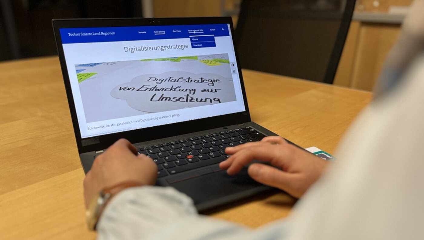Eine Person sitzt an einem Laptop.