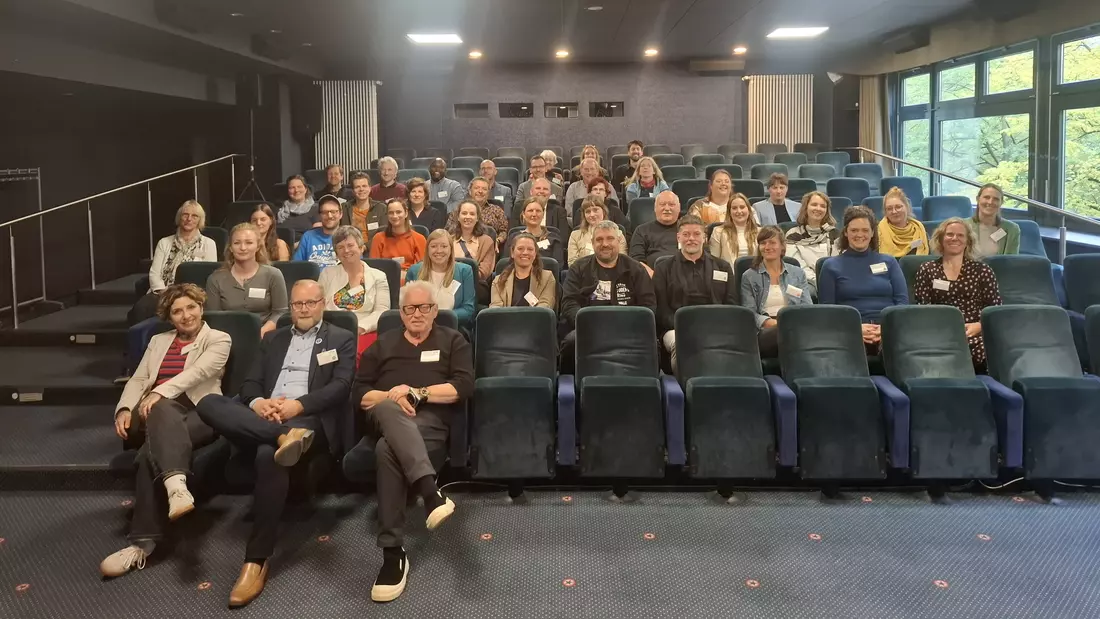 Teilnehmende des ersten Vernetzungstreffens von Soziale Dorfentwicklung sitzen in einem Kinosaal.