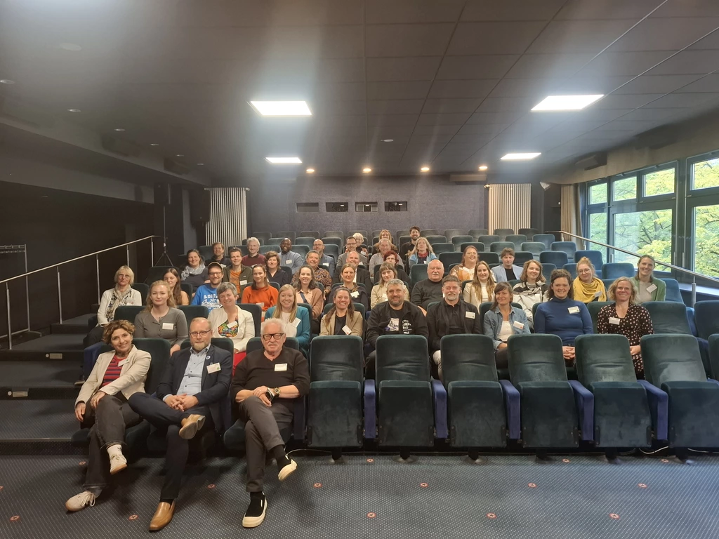 Teilnehmende des ersten Vernetzungstreffens von Soziale Dorfentwicklung sitzen in einem Kinosaal.