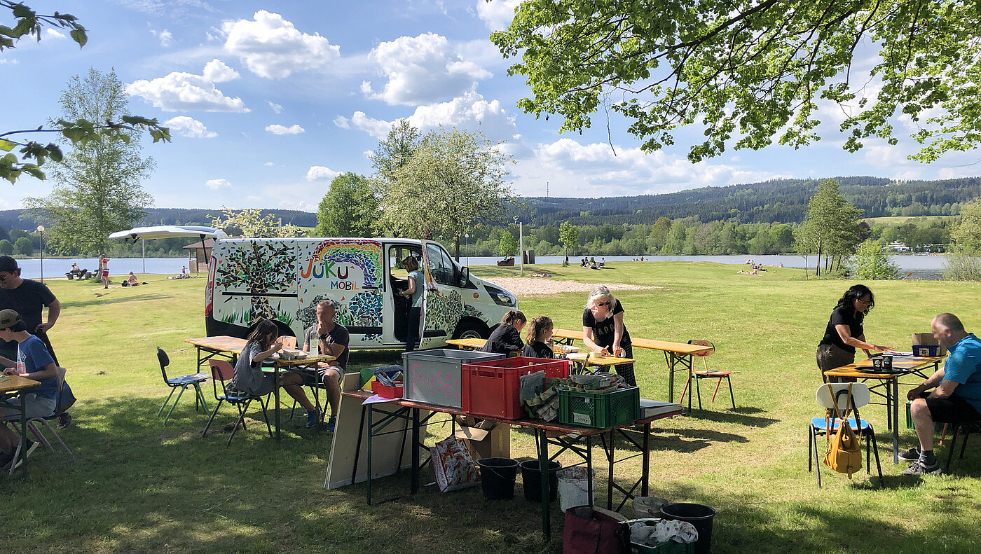 Bänke einer mobilen Kunstschule sind auf einer Wiese aufgebaut