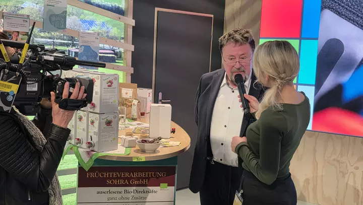 Der Initiator des Projekts Früchteverarbeitung Sohra GmbH im Gespräch mit der Moderatorin des Hallen-TV.
