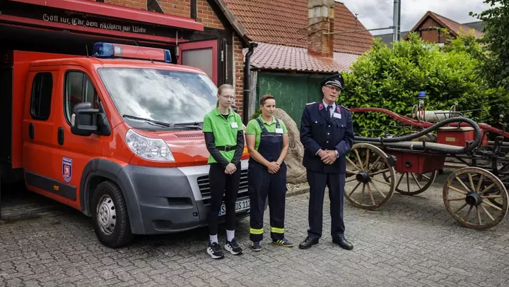 Feuerwehrauto steht vor der Garage mit Engagierten