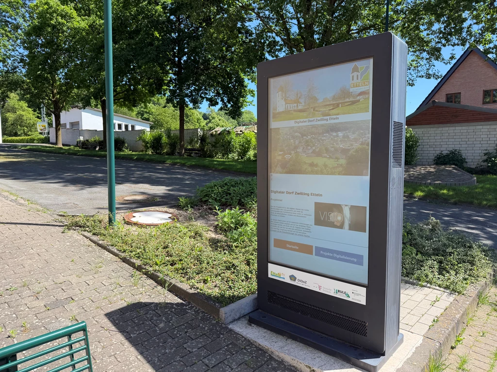 Eine Stele mit eingebettetem Display zeigt verschiedene Menüs, mit denen Etteln digital erkundet werden kann.