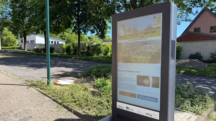 Eine Stele mit eingebettetem Display zeigt verschiedene Menüs, mit denen Etteln digital erkundet werden kann.