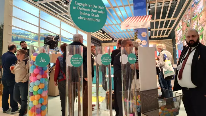 Abstimmungsmöglichket zum Thema Ehrenamt mit bunten Bällen in Glasröhren.