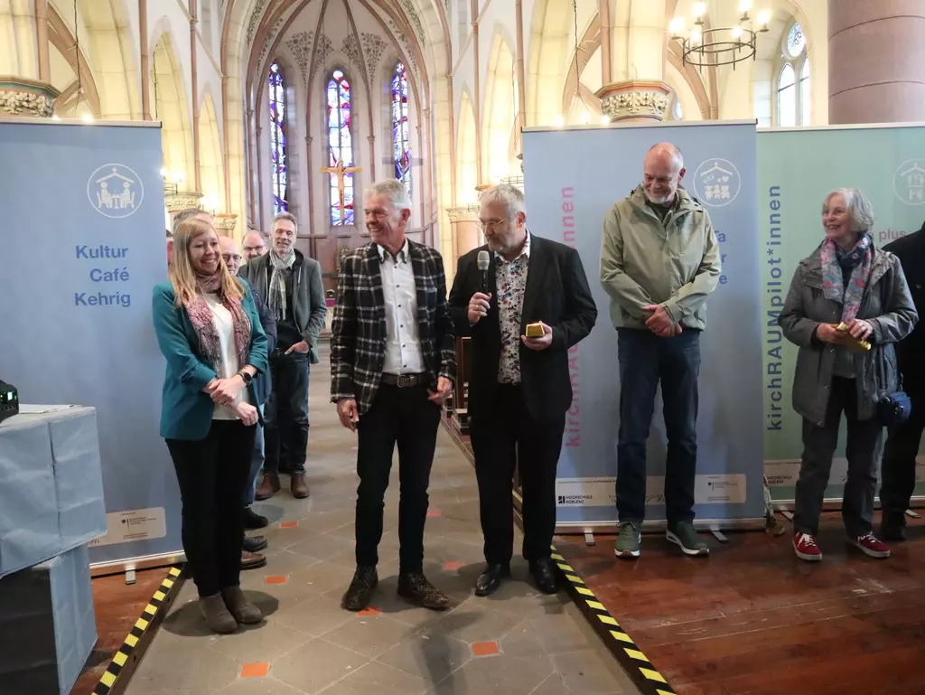 Mehrere Personen stehen in einer Kirche.