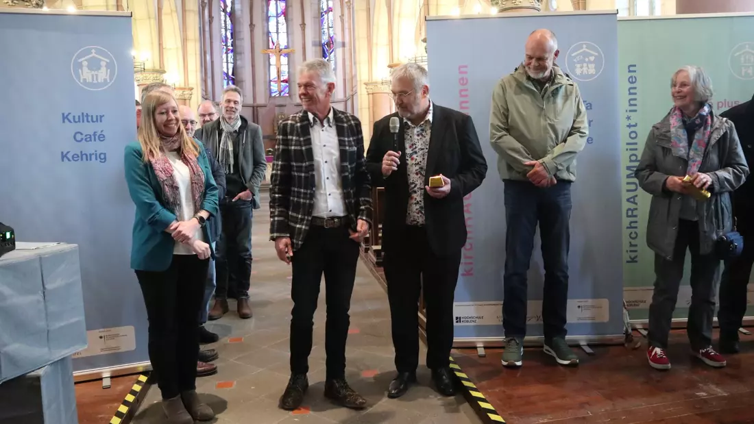 Mehrere Personen stehen in einer Kirche.