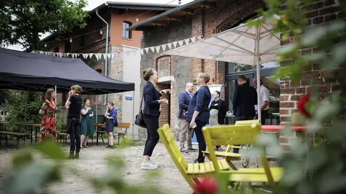 Menschen stehen auf dem Gelände des Hofs Prädikow