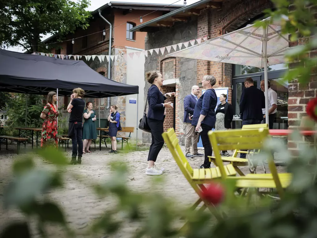 Menschen stehen auf dem Gelände des Hofs Prädikow