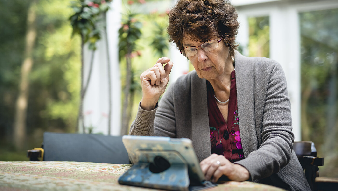 Eine Frau sitzt vor einem Tablet