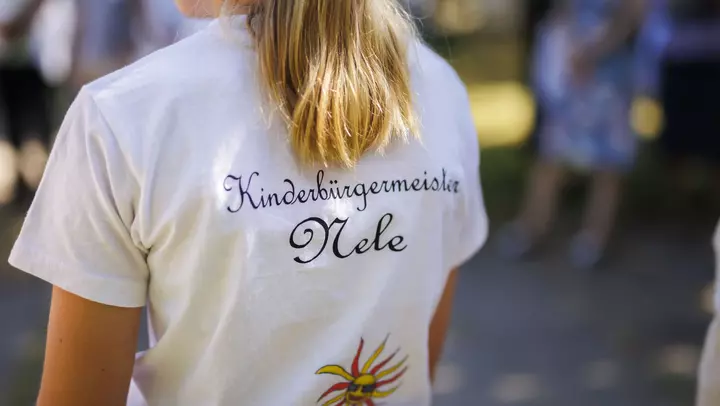 Mädchen mit Aufschrift "Kinderbürgermeisterin Nele" auf dem T-Shirt